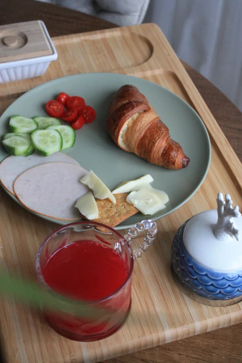 Imagen de ejemplo de BookNoFees: bandeja de desayuno con un croissant, verduras y zumo