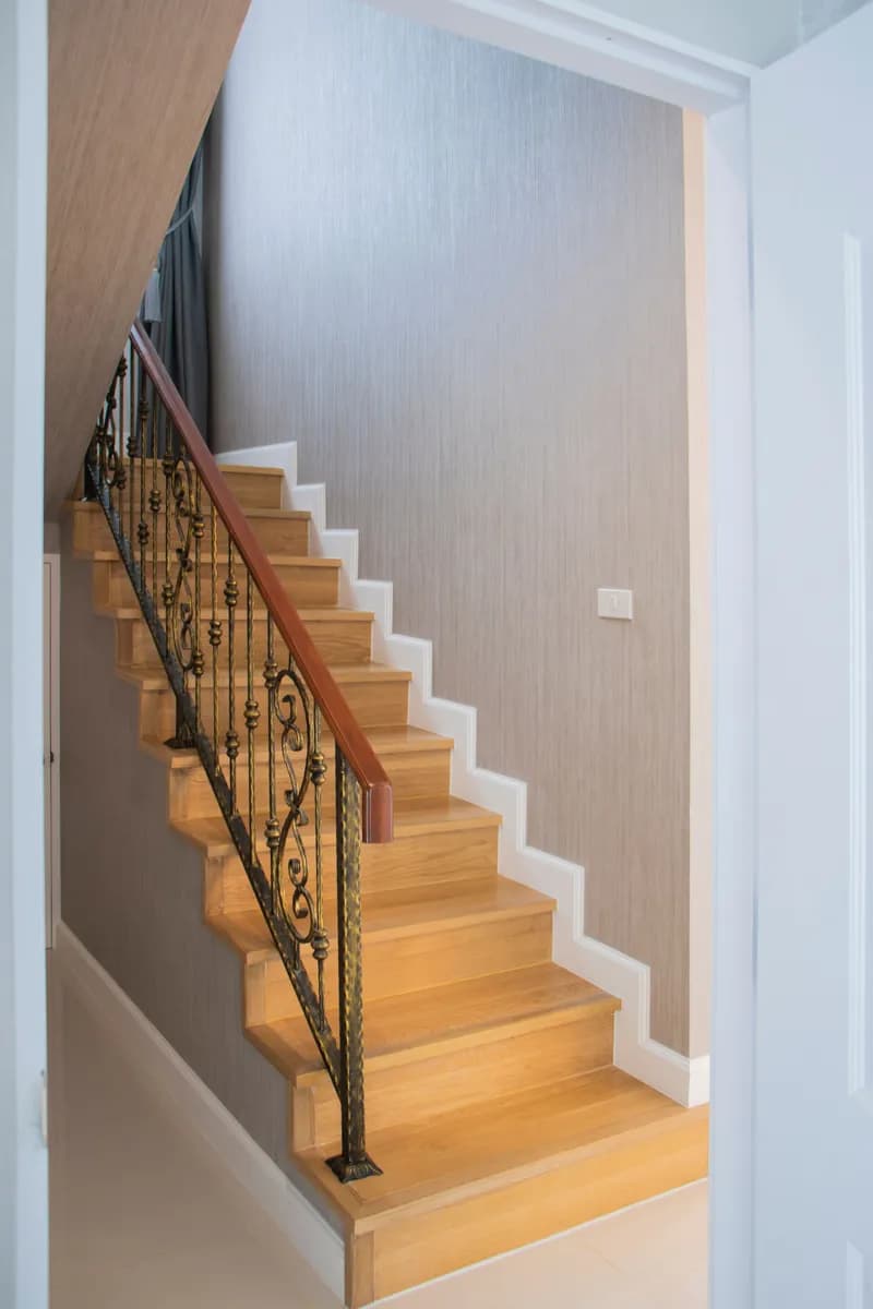 Imagen de ejemplo de BookNoFees: escalera de madera con barandilla metálica en un interior luminoso