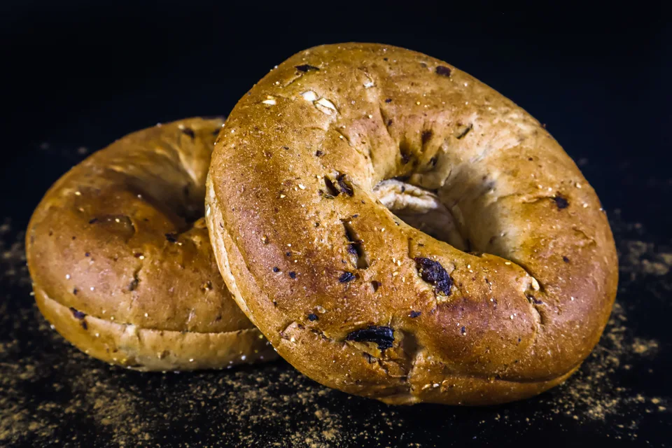 BookNoFees: Foto de ejemplo: Dos bagels de color dorado sobre un fondo oscuro